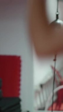 Kulaklıklı bir dövüşçü spor salonunda yumruk torbasıyla yumruklarını eğitip kaçmayı başarıyor.