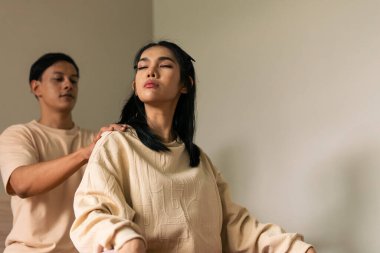 Bir kadın erkeklerden omuz masajı alıyor, rahat ortamlarda terapi ve sağlık deneyimi yaşıyor.