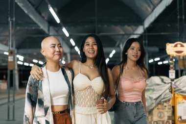 Genç, çeşitli kadınlar birlikte yürüyor, gülüyor ve gülüyor, arkadaşlığı ve tasasız yaşam tarzını kutluyor.