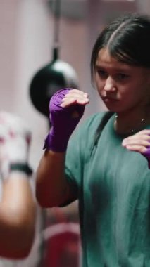 Ellerinde bandajlarla bir boks salonunda eğitilmiş iki genç kız FullHD dikey