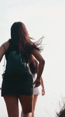 İki genç kadın, açık hava maceraları sırasında güneşli havanın tadını çıkarıyorlar.