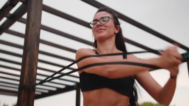 Spor salonunda direniş bantlarıyla spor yapan atletik bir kadın.