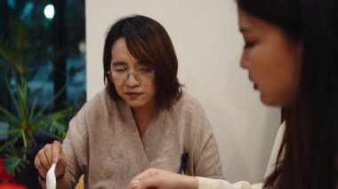 İki Asyalı bayan arkadaş birlikte yemek yiyor, yemek yiyor ve modern bir restoranda sohbet ediyorlar.