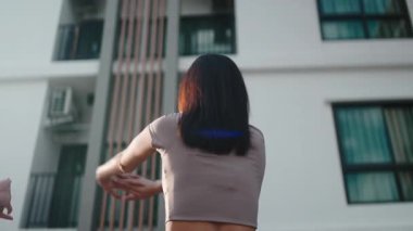 Atletik kadın antrenmandan önce ısınıyor, kollarını ve sırt kaslarını dışarıda geriyor.