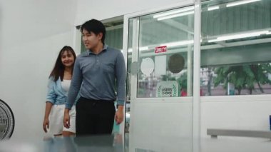 Mutlu genç Asyalı çift ilk buluşmaları için bir restorana giriyor ve yemek seçiyorlar.