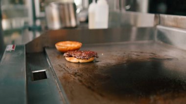 Ticari hayalet mutfağındaki ızgarada köfte pişirmek, yemek servisini temsil ediyor.