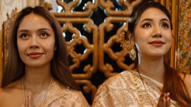 Geleneksel Loi Krathong kutlamalarında saygı gösteren iki Taylandlı kadın.