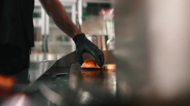 Profesyonel aşçı, bir restoranın mutfağında ızgara ızgara ekmeğin üstünde brioche burger pişiriyor ve kızartıyordu.