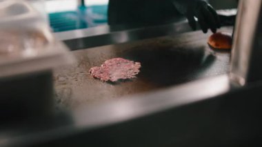 Profesyonel aşçı sıcak bir restoranın ızgarasında köfte pişiriyor.