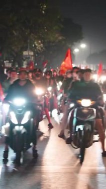 Vietnamlı futbol taraftarlarının neşeli kalabalığı mobiletlerle milli takım zaferini kutluyorlar.