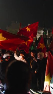 Vietnamlı futbol taraftarları ulusal bayraklarını sallayarak gece zaferini kutluyorlar.