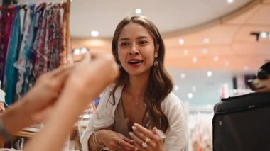 Güzel Asyalı kadın köpeğiyle bir kasiyerde kredi kartıyla ödeme yapıyor.