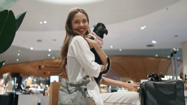 Taylandlı kadınlar evcil köpekleriyle modern bir alışveriş merkezinde alışveriş yapıyorlar.