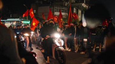 Vietnamlı taraftarlar ellerinde ulusal bayraklarla sokakta futbol zaferini coşkuyla kutluyorlar.