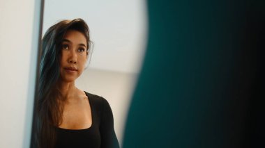 Taylandlı kadın, düşünceli bir ifadeyle, güçlü ve sağlıklı görünüyor.