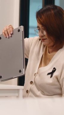 Başarılı orta yaşlı Asyalı girişimci laptopunu açıp ofis masasında çalışmaya başladı.