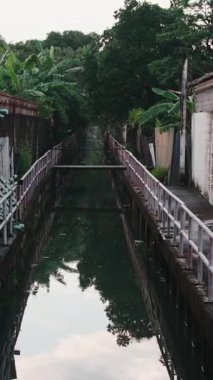 Geleneksel bir Thai köyünde küçük bir su yolu üzerinde romantik bir ilk buluşma yaşayan genç çift.