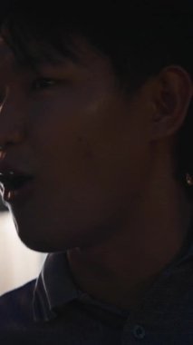 Genç Asyalı kadın ve erkek romantik bir buluşma sırasında şehirde samimi bir konuşma yapıyorlar.