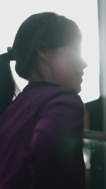 Güzel Asyalı kadın dışarıda yoga yapıyor. Arkasında güçlü bir ışık var. Mercek patlaması yaratıyor.