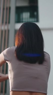 Atletik bir kadının şehir ortamında yoga ve esneme egzersizleri yaptığı arka plan.