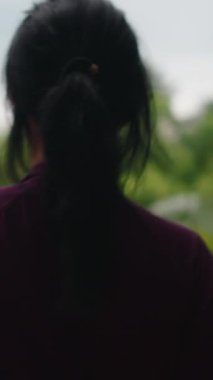 Sağlıklı genç Asyalı kadın güzel bir günde yoga seansından önce terasta geriniyor.