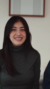 Genç Asyalı çift gülümsüyor ve doğum günü kutlaması için komik parti gözlükleri takıyor.