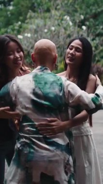 Bir grup bayan arkadaş kemoterapiden sonra kel bir kadını rahatlatıyor ve destekliyor.