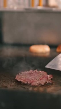 Profesyonel bir restoranın mutfağında ızgaranın üstünde köfte pişiren bir şefe yaklaş.