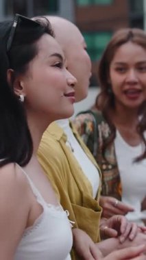 Mutlu Asyalı bir grup genç kadın, bunlardan biri de alopesia 'lı, dışarıda birlikte vakit geçirmenin keyfini çıkarıyorlar.