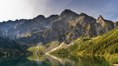 Dağın arka planında bir turistle manzaralar ve akşam aydınlatmalı göller.