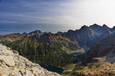 Dağın arka planında bir turistle manzaralar ve akşam aydınlatmalı göller.