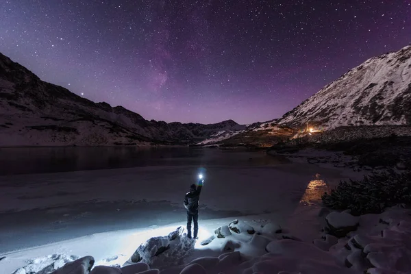 Kışın yıldızlı gökyüzü Polonya Tatraları buzla kaplı bir dağ gölü yakınında