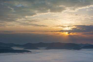 Karpat dağlarında sisli ve dramatik gökyüzü ile güzel bir gün doğumu.