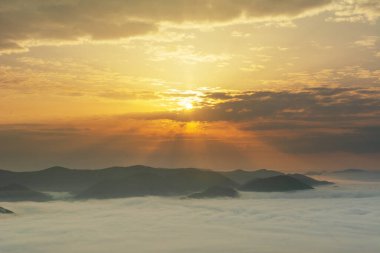 Karpat dağlarında sisli ve dramatik gökyüzü ile güzel bir gün doğumu.