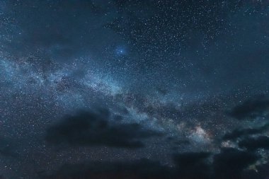 Çadırları olan turistlerin arka planında parlak Samanyolu ile uzay yıldızlı geceler.