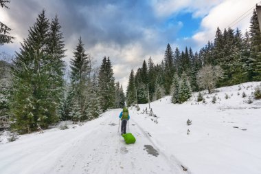 Turist kışın Ukrayna Karpatları 'nın dağ rotalarında sürüklenerek seyahat eder.