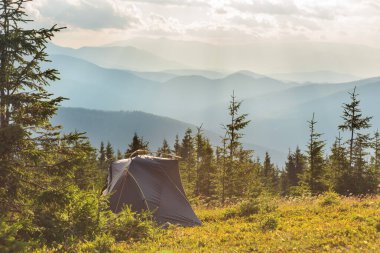Etrafı güzel manzaralı bir turist çadırıyla dağlarda yaz tatili.