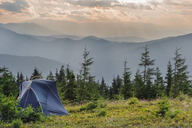 Etrafı güzel manzaralı bir turist çadırıyla dağlarda yaz tatili.