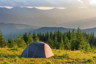 Etrafı güzel manzaralı bir turist çadırıyla dağlarda yaz tatili.