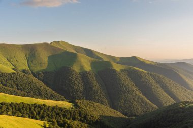 Borzhava 'daki Ukrayna Karpatlar' da yaz akşamı dramatik bir gün batımı ve turistler onu izliyor.