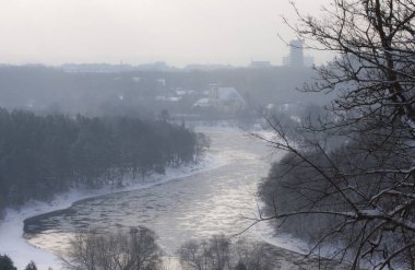 Güneşli bir kış gününde buz kütleleri donmuş bir nehirde yüzer. Litvanya, Vilnius yakınlarındaki Neris Nehri. Verkiu Park 'taki yüksek tepeden bak..