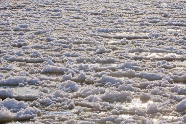 Güneşli bir kış gününde buz kütleleri donmuş bir nehirde yüzer. Litvanya 'nın doğusundaki Neris Nehri' nde buz oluştu..