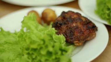 Kız pirzola marul yaprakları üzerine koyar.