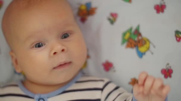 Bebé mira a la cámara — Vídeos de Stock