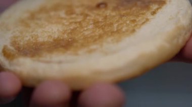 Cook bir yağ burger çörek üzerinde yayılır.