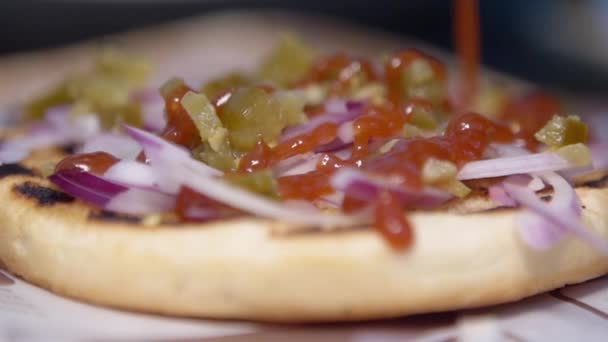 Cuoco diffonde una salsa rossa su un panino — Video Stock