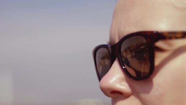 The city reflects in the girl's sunglasses — Stock Video