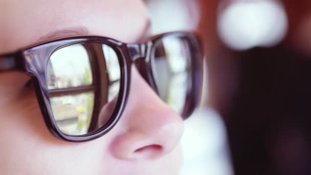 La ciudad se refleja en las gafas de sol de la chica — Vídeos de Stock