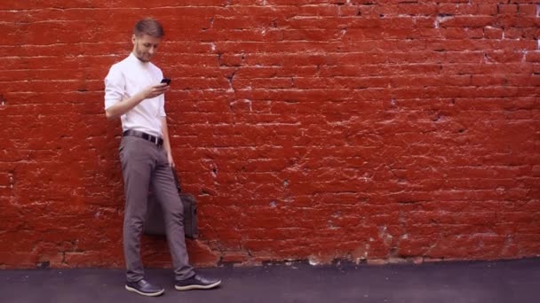 Homem de negócios usando smartphone e sorrindo — Vídeo de Stock