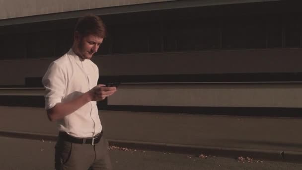 Бизнесмен с помощью смартфона на улице — стоковое видео